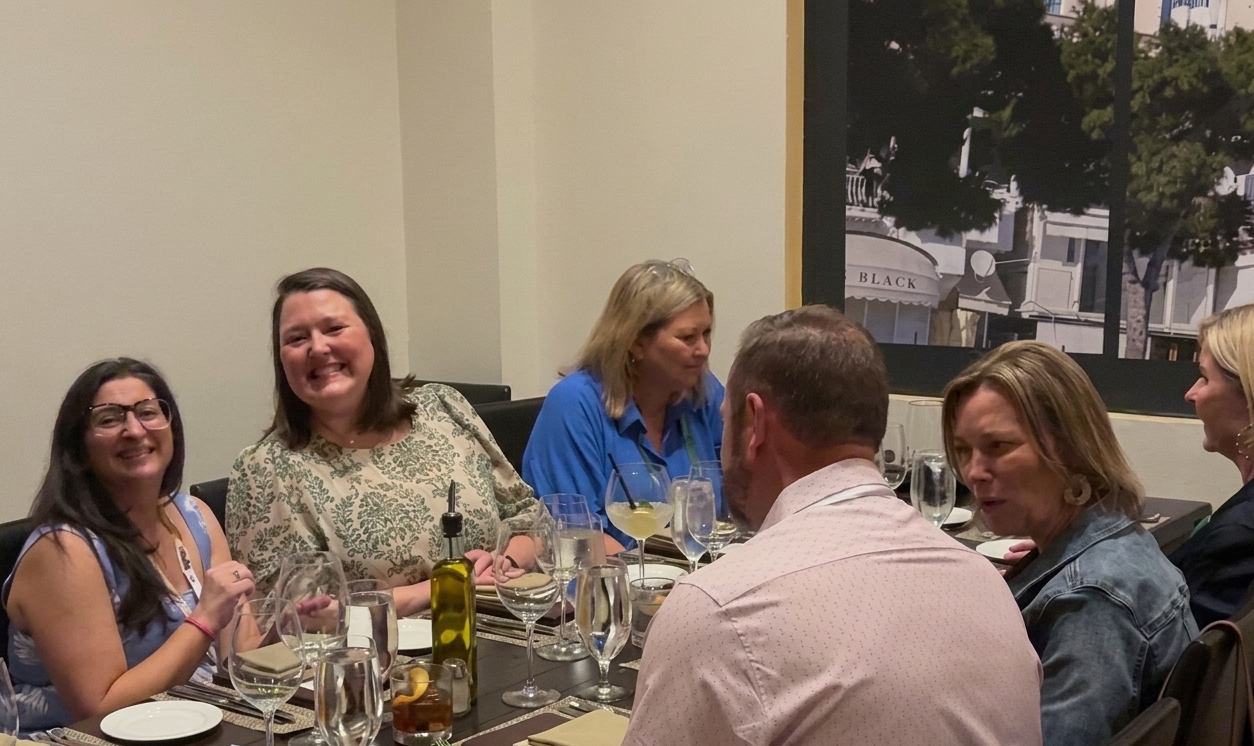 Healthcare professionals networking over dinner at AAPPR conference, discussing workforce strategy and collaboration in a restaurant setting.