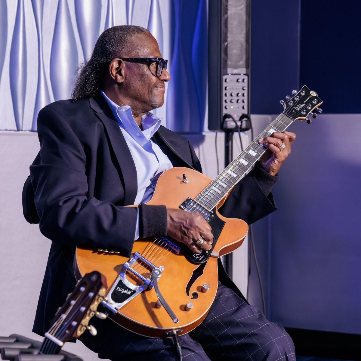 A guitarist performing live music during an evening event at the 2026 NALTO Fall Fly-In