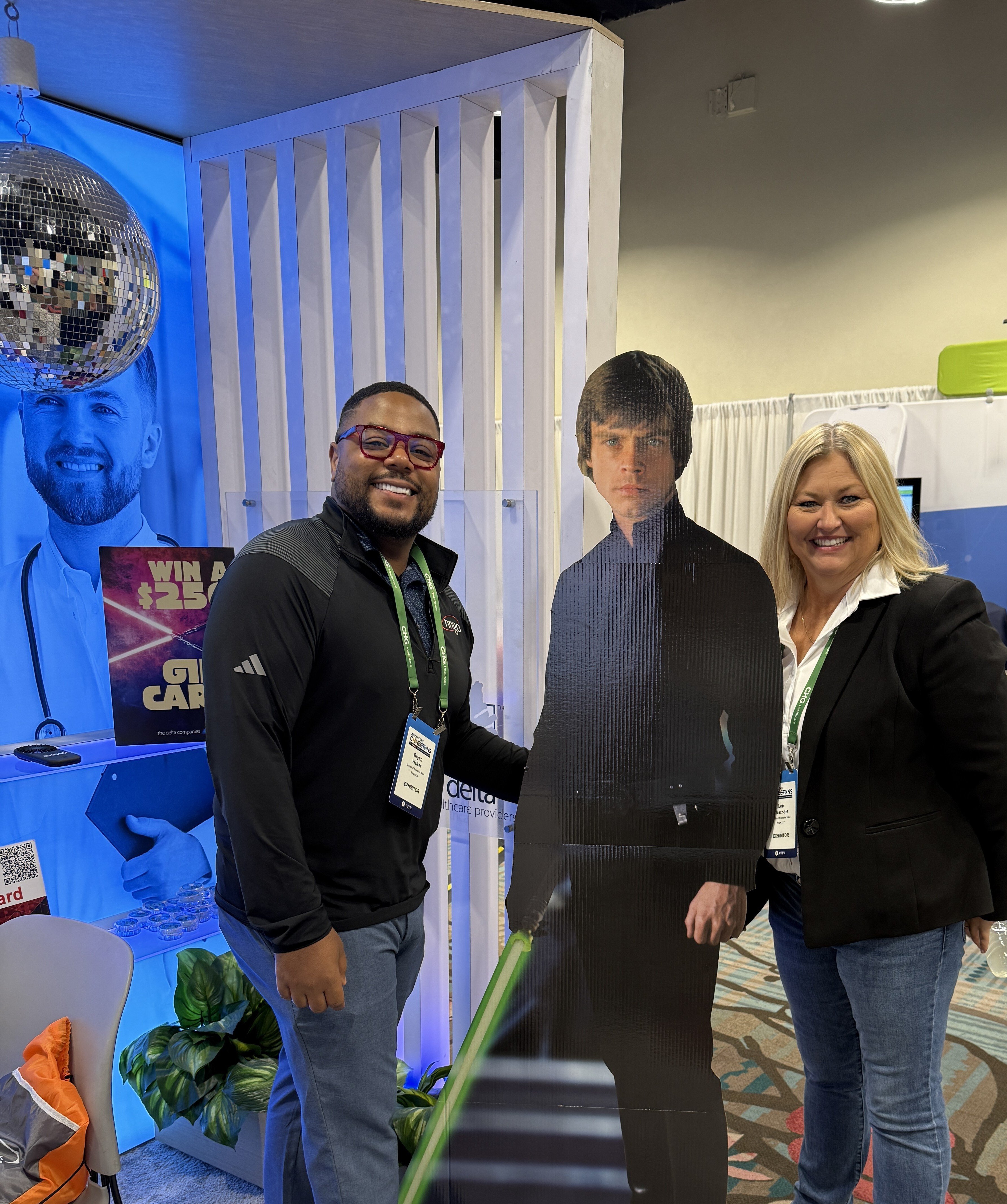Healthcare professionals at AAPPR conference engaging at exhibit booths, posing with themed Star Wars display during networking event.