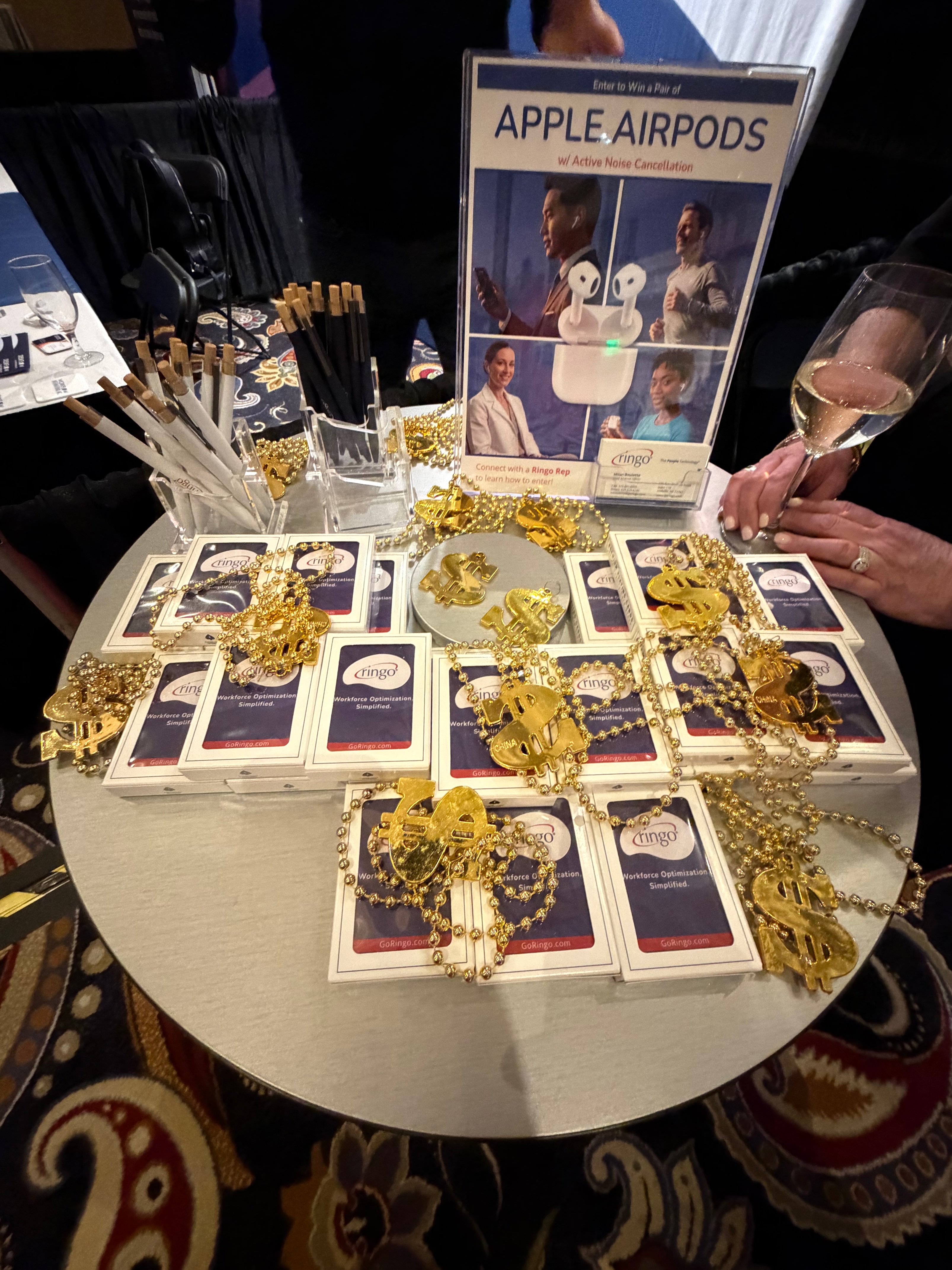 Ringo booth 403 giveaway display at NALTO/NAPR Conference in Las Vegas, featuring Apple AirPods raffle entry sign, healthcare workforce management promotional materials, vendor-neutral VMS branding, and conference swag at the Bellagio.