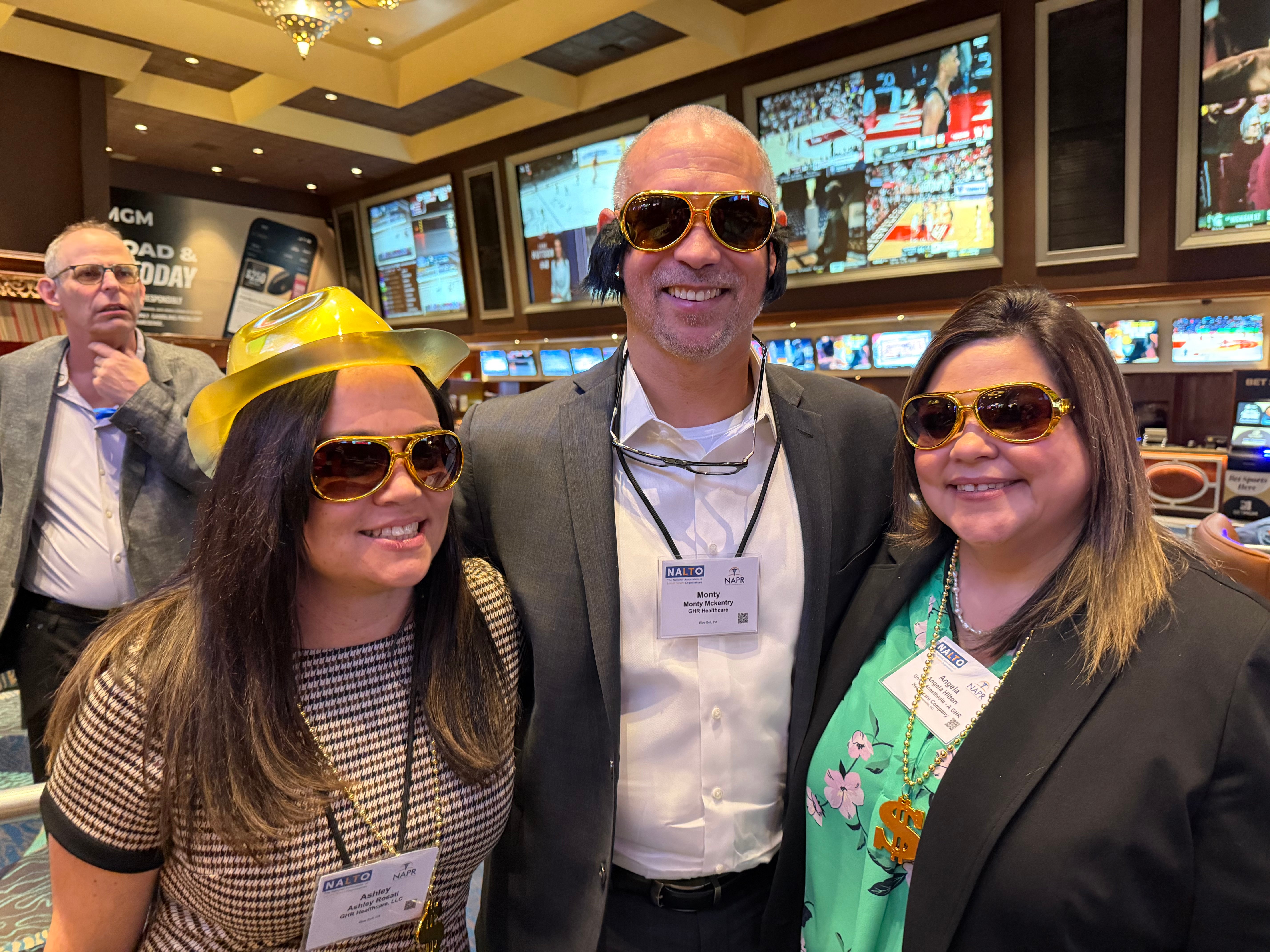 Healthcare staffing leaders wearing gold sunglasses at NALTO/NAPR 2026 in Las Vegas, connecting with Ringo’s vendor-neutral healthcare workforce management team at Booth 403.