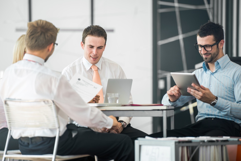 A group of corporate people working by the office table.jpeg A group of corporate people working by the office table.jpeg