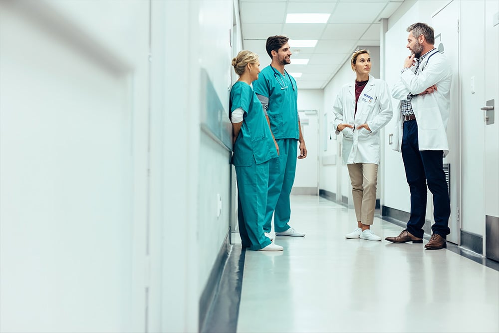 Team of doctors having discussion in hospital corridor