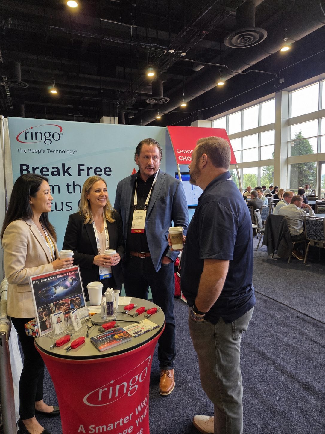 Ringo team members talking and laughing with an attendee at the Ringo booth