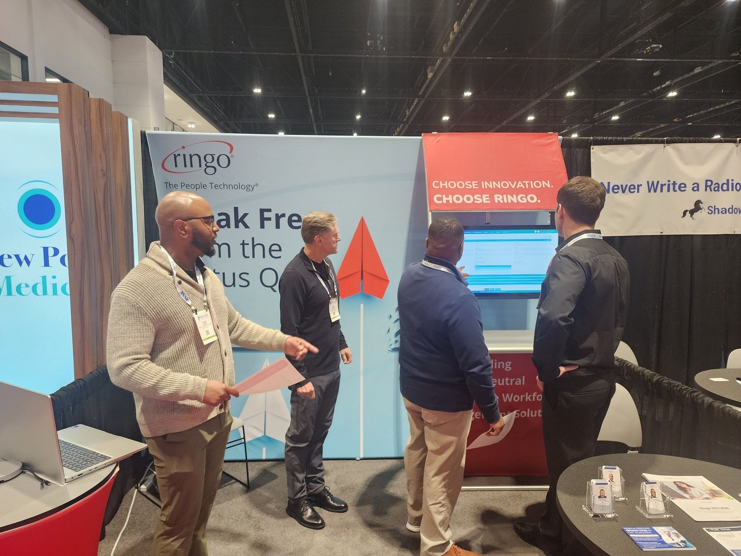 Attendees gathered around a live Ringo VMS demo at the booth